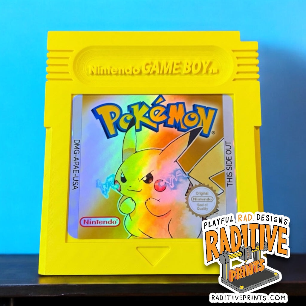 Large yellow game cartridge with a ruler showing size with a blue background.  3D Printed with a pokemon style sticker on the front